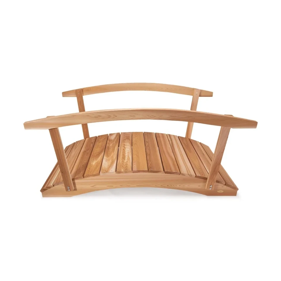 Arched 6 ft cedar garden bridge with handrails on both sides spanning a garden bed